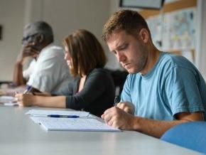 Seminary students writing at table in classroom